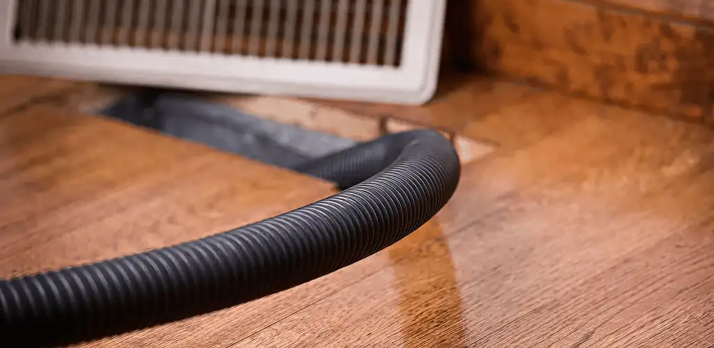 Air duct cleaning hose inserted into a floor vent for ductwork cleaning in Oakland, CA